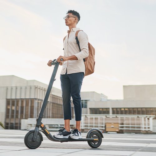 Junger Mann fährt auf einem E-Scooter durch die Stadt